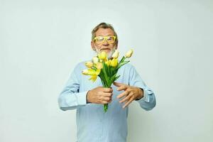 personnes âgées homme dans une bleu chemise avec une bouquet de fleurs tondu vue photo