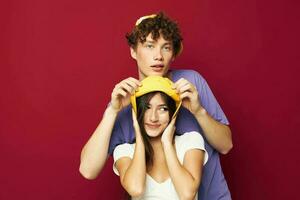 une Jeune couple dans coloré t-shirts élégant vêtements Chapeaux jeunesse style photo