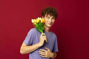 une Jeune homme en portant une Jaune bouquet de fleurs violet t-shirts rouge Contexte inchangé photo