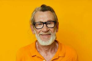 un personnes âgées homme avec des lunettes dans une Jaune T-shirt avec des lunettes fermer photo