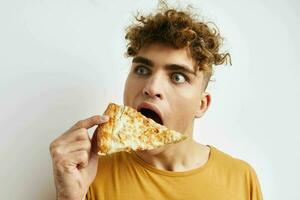 pervers gars dans une Jaune T-shirt en mangeant Pizza mode de vie inchangé photo