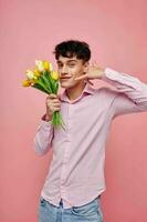 portrait de une Jeune homme bouquet de fleurs Date romance posant rose Contexte inchangé photo