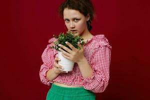 Jeune femme debout et en portant fleur dans pot fermer inchangé photo