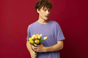 une Jeune homme en portant une Jaune bouquet de fleurs violet t-shirts rouge Contexte inchangé photo