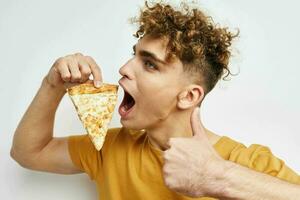 pervers gars dans une Jaune T-shirt en mangeant Pizza mode de vie inchangé photo