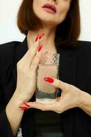 attrayant femme dans une costume verre de l'eau posant isolé Contexte photo