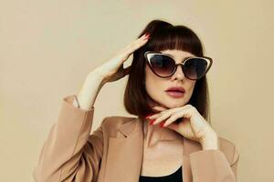 attrayant femme charme rouge ongles modèle luxe des lunettes de soleil isolé Contexte photo