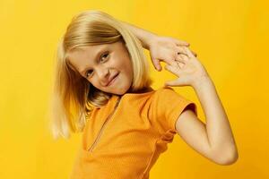 enfant fille dans une Jaune T-shirt sourire posant studio isolé Contexte inchangé photo