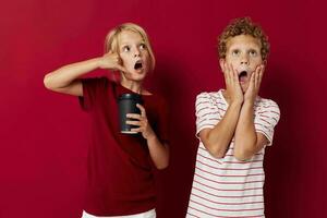 marrant des gamins jetable verre avec une boisson enfance émotions photo