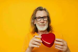 photo de retraité vieux homme Jaune T-shirt et des lunettes posant en forme de coeur boîte Jaune Contexte