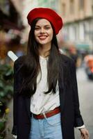 femme sourire mode modèle des promenades sur le rue dans le ville centre parmi le foule dans une veste et rouge béret et jeans, cinématique français mode style vêtements, Voyage à Istanbul printemps photo