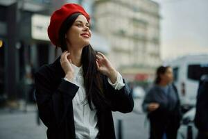 femme sourire avec les dents touristique des promenades des promenades dans le ville sur le Contexte de Bureau bâtiments, élégant à la mode vêtements et se maquiller, printemps marcher, Voyage. photo