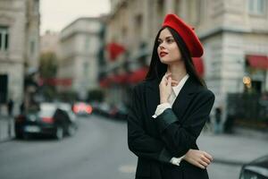 mode femme portrait permanent sur le rue dans de face de le ville dans élégant vêtements avec rouge lèvres et rouge béret, voyage, cinématique couleur, rétro ancien style, Urbain mode mode de vie. photo