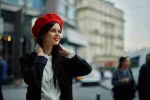 femme sourire avec les dents touristique des promenades des promenades dans le ville sur le Contexte de Bureau bâtiments, élégant à la mode vêtements et se maquiller, printemps marcher, Voyage. photo