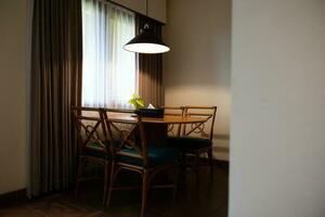 foncé Accueil intérieur avec bois à manger table allumé par lampe, soir lumière pour dîner. photo