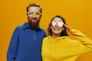 homme et femme couple souriant gaiement et courbé avec lunettes, sur Jaune arrière-plan, symboles panneaux et main gestes, famille tirer, jeunes mariés. photo