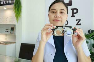 femelle ophtalmologiste en portant lunettes à l'intérieur clinique, œil médecin en portant des lunettes dans lunettes boutique, ophtalmologiste en portant lunettes dans monocle clinique photo