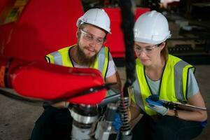 tous les deux de ingénieurs installation et essai une grand robotique bras. avant Envoi en cours il à les clients pour utilisation dans le industrie photo