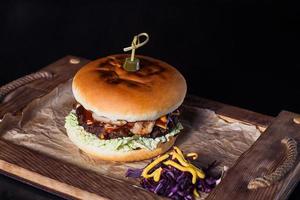 cheeseburger sur un plateau en bois dans un restaurant, sur fond sombre photo
