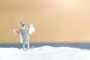 personnes miniatures, couple de mariage heureux sur une plage blanche, concept de mariage photo