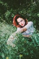 jeune et belle femme rousse posant en pleine nature photo