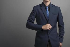 Close up of businessman in blue suit confiant sur fond gris photo