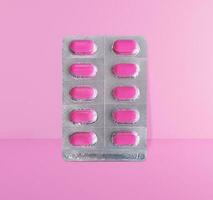 paquet de rose pilules sur rose mur, médicament concept photo
