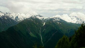 une panoramique vue sur le enneigé pics. plus grand Caucase Montagne intervalle photo