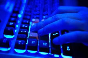 le joueur utilise un clavier de jeu en néon bleu photo
