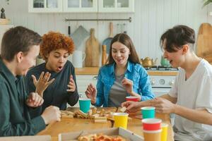 Accueil faire la fête. copains dépenses temps ensemble en jouant dans planche Jeu crash en bois la tour à maison. content diverse groupe ayant amusement ensemble intérieur. mixte course Jeune copains meilleur copains profiter fin de semaine. photo