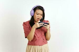 en jouant mobile Jeu sur téléphone intelligent avec casque de musique de magnifique asiatique femme isolé sur blanc photo