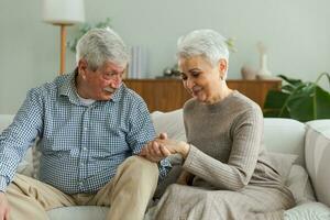 Sénior adulte mature couple dans l'amour en portant mains à maison. milieu âge vieux mari et épouse à la recherche avec tendresse l'amour profiter bien-être. grand-mère grand-père ensemble. famille moment l'amour et se soucier. photo