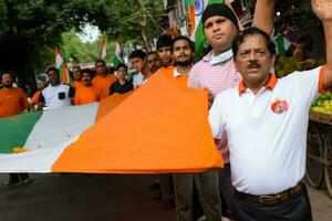 Delhi, Inde -15 juin 2023 - grand groupe de gens pendant gros tiranga yatra organisé comme partie de le azadi ka amrit mahotsav à célébrer le 76 anniversaire de l'Inde indépendance, Indien drapeau Mars photo