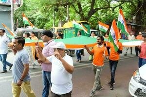 Delhi, Inde -15 juin 2023 - grand groupe de gens pendant gros tiranga yatra organisé comme partie de le azadi ka amrit mahotsav à célébrer le 76 anniversaire de l'Inde indépendance, Indien drapeau Mars photo