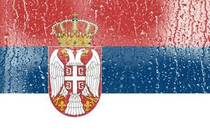 3d drapeau de Serbie sur une verre avec l'eau laissez tomber Contexte. photo