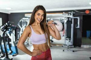 image de Jeune attrayant femelle Faire bouilloire cloche exercice sur Gym Contexte. aptitude femme travail dehors. crossfit exercer. photo