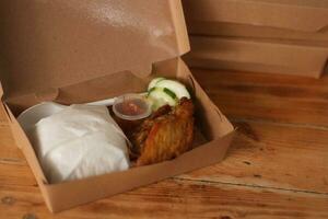 frit poulet dans une boîte sur une en bois tableau. photo