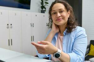 magnifique femme sourit à caméra, en utilisant intelligent regarder pour sans argent Paiement le médical prestations de service dans une bancaire Terminal. nfc photo