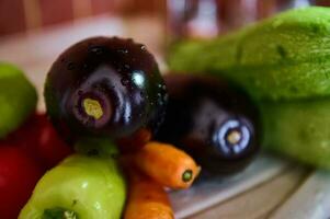 sélectif concentrer sur Frais mûr biologique des légumes avec gouttes de l'eau dans le cuisine couler. nourriture Contexte. encore la vie photo