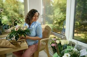 fleuriste femme crée magnifique bouquet avec exotique orchidée fleurs à floral conception studio. magasin et livraison un service photo