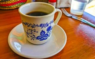 pot de tasse blanc bleu avec table basse en bois noir mexique. photo