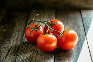 une branche de mûr tomates sur une Coupe planche dans le cuisine. photo