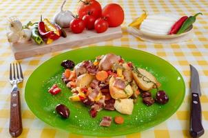 pommes de terre au four avec bacon, paprika, carottes, oignons et plusieurs épices, herbes et olives servies sur assiette. photo