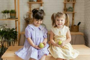 peu content les filles imbécile autour dans le cuisine et manger pommes photo