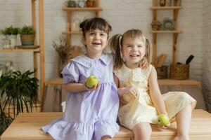 peu content les filles imbécile autour dans le cuisine et manger pommes photo