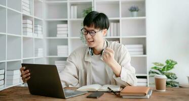 portrait de une asiatique Jeune homme séance à le sien bureau dans le bureau. photo