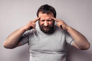 homme barbu frustré touchant sa tête avec les mains photo