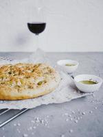 pain focaccia italien traditionnel aux olives, romarin, sel et huile d'olive. fougasse maison. photo