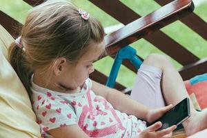 jeune enfant d'âge préscolaire utilisant un smartphone pour enfants utilisant la technologie numérique photo