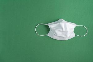 masque chirurgical sur fond vert minimaliste